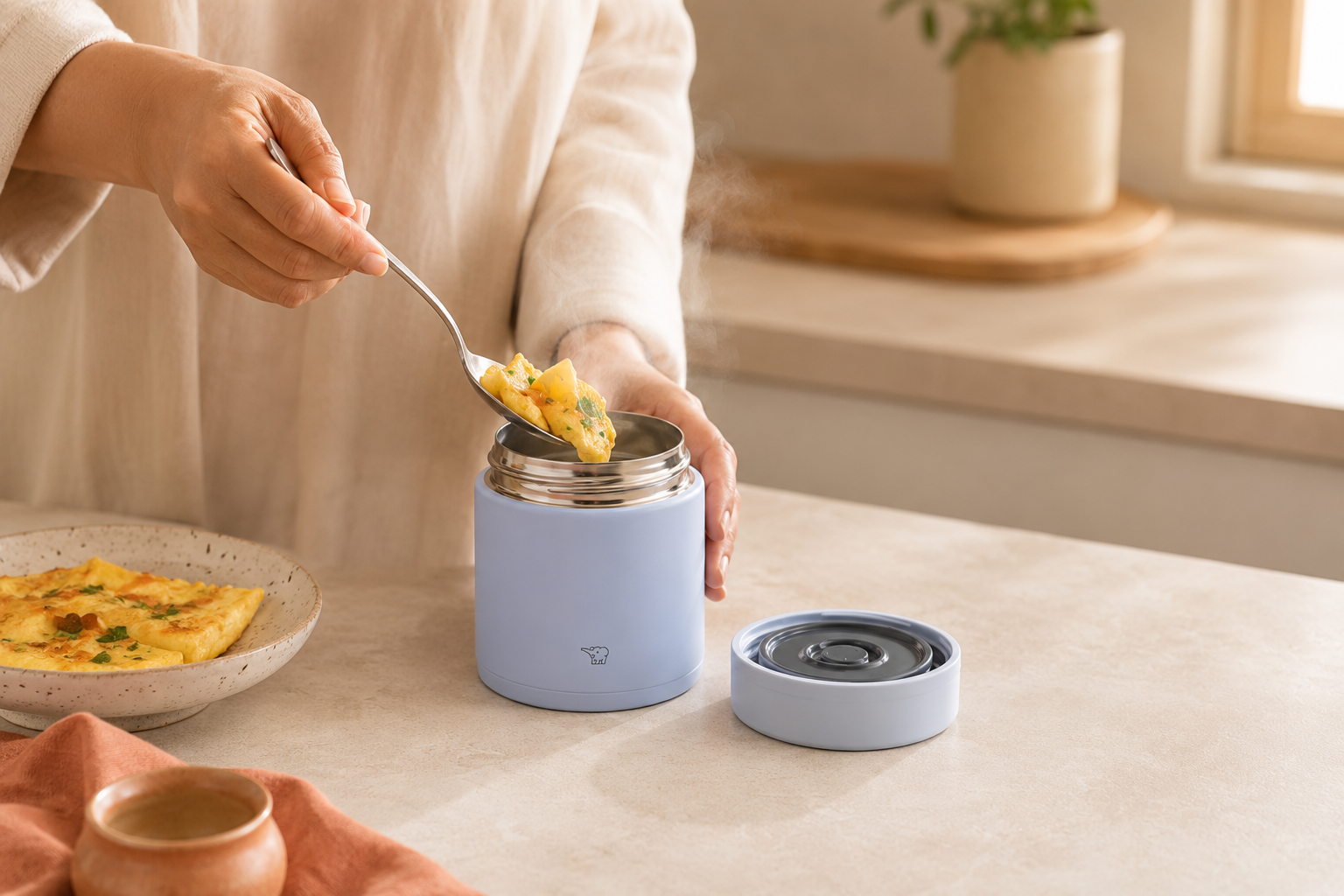 حافظة طعام زوجيروشي للدوام — Zojirushi insulated food jar with hot lunch on an office desk